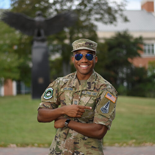 Serviceman in uniform with arms up, smiling with sunglasses on